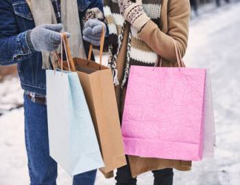 couple holding bags shopping in the snow 