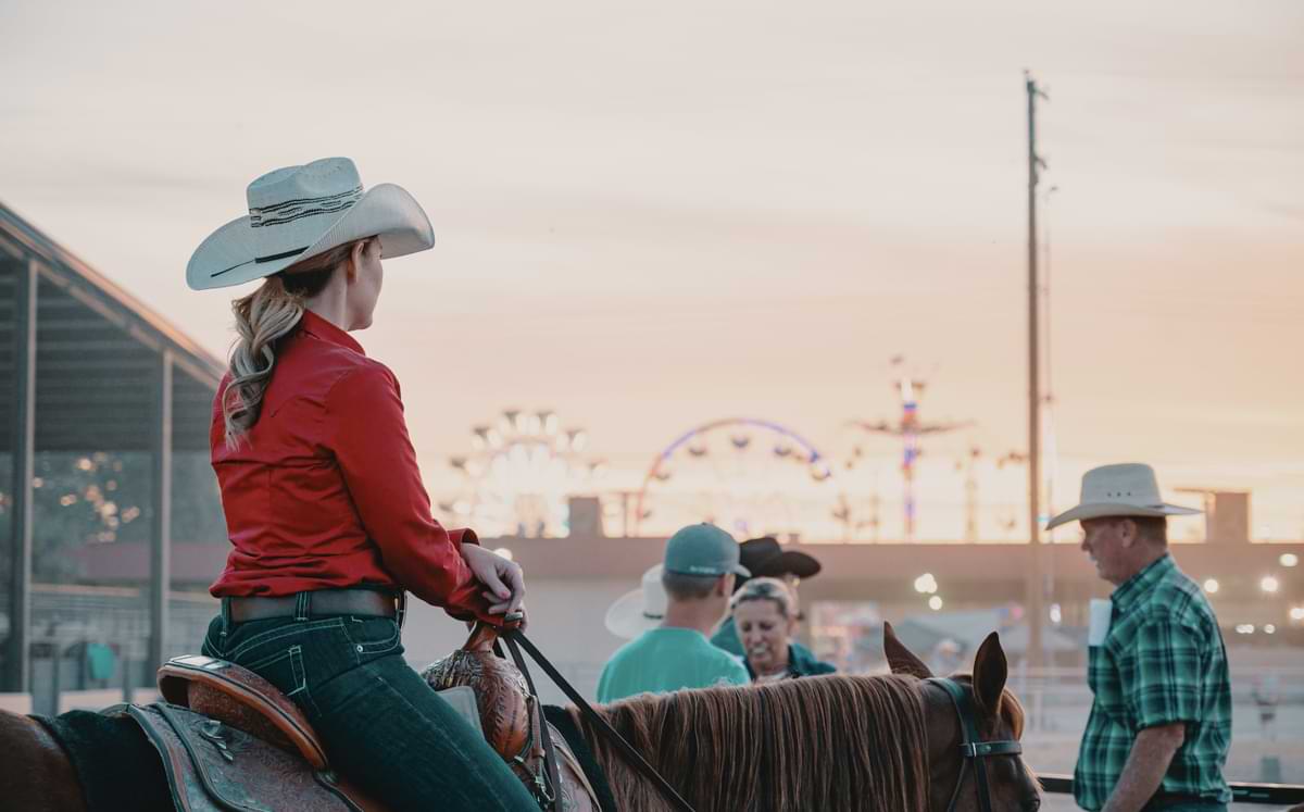 woman in cowboy hat riding horse